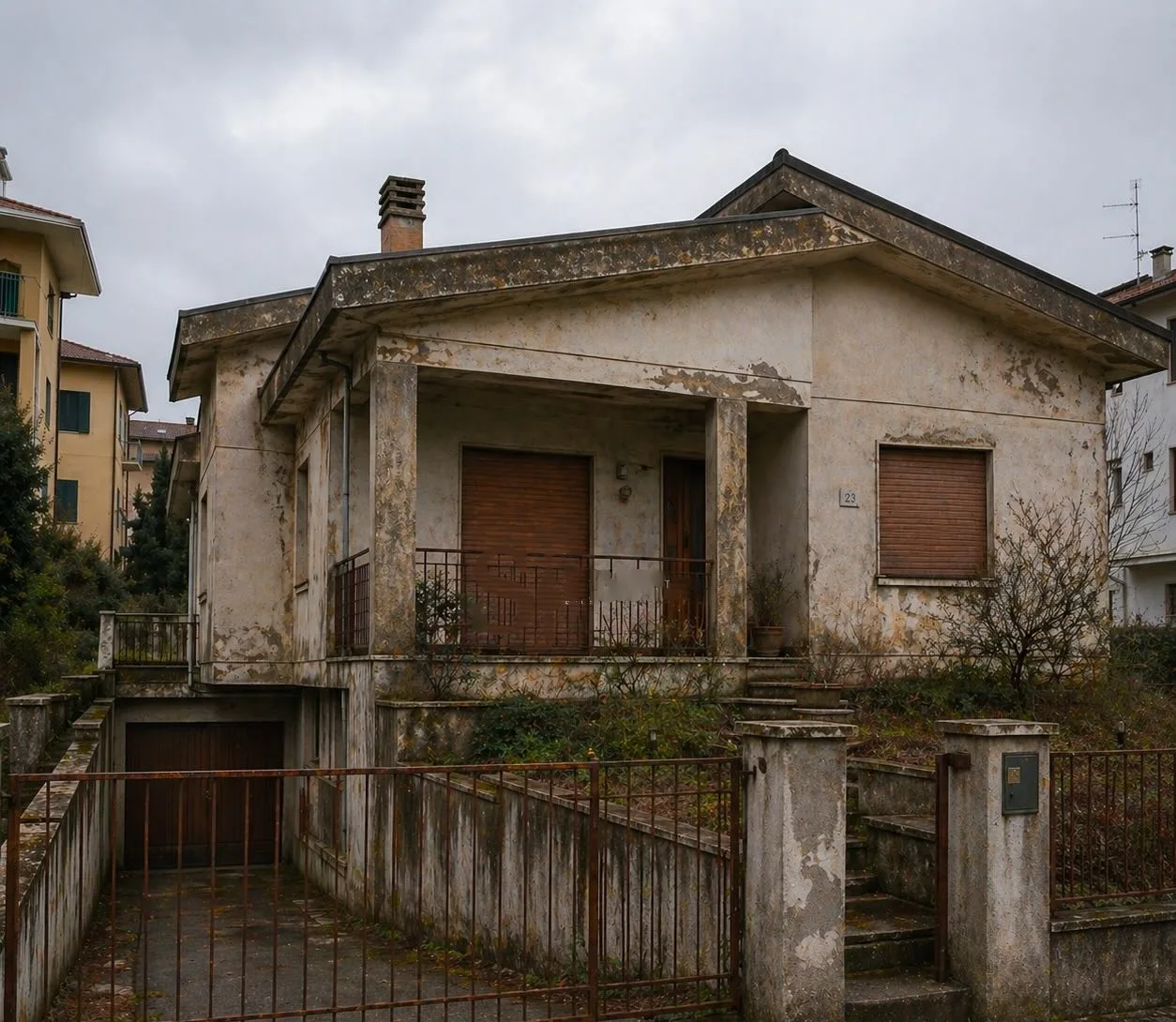La villetta prima dei lavori: intonaco scrostato, tapparelle chiuse e cancello arrugginito